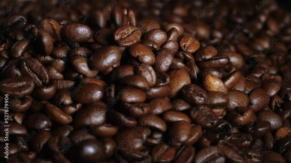 close-up of arabica coffee beans pouring into a hill of grains background close-up of arabica coffee beans pouring into a hill of grains background