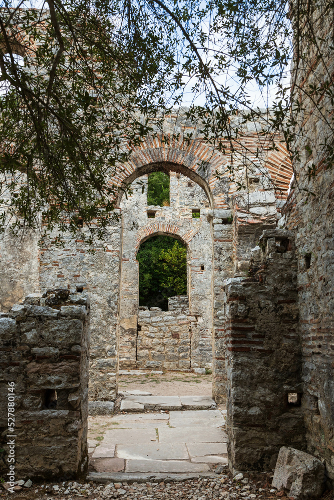 Entrance with an arch to an ancient church located in Butrint national park, part of UNESCO heritage. Saranda, Albania