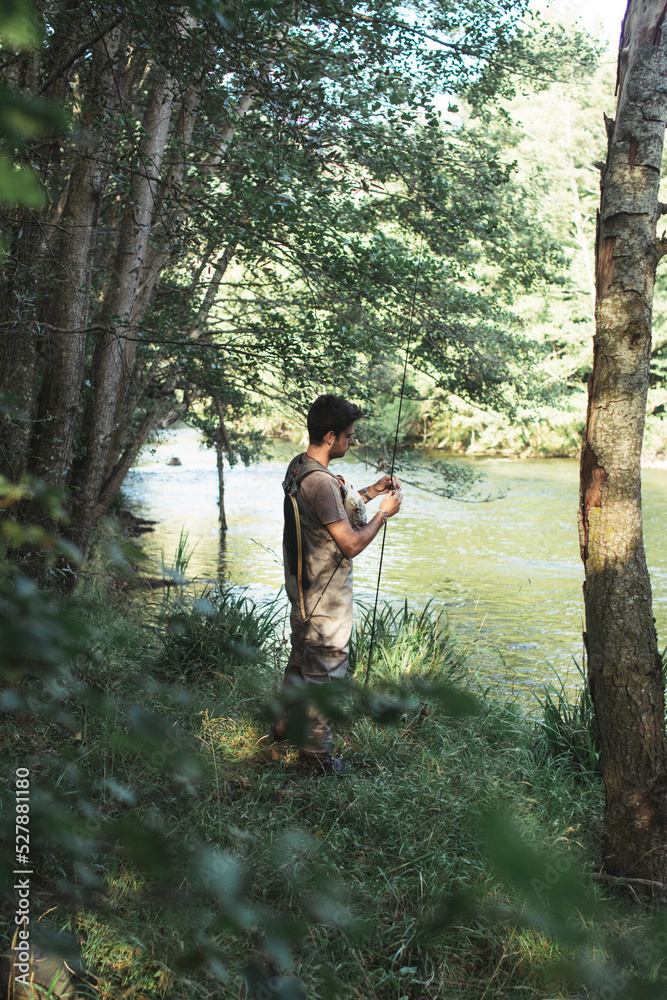Man preparing fishing rod into river