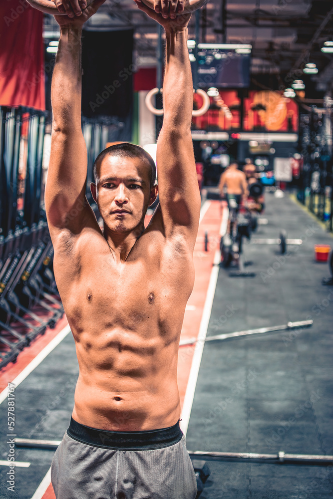 Fitness handsome shirtless young man doing dipping exercise using rings in the gym Fitness handsome shirtless young man doing dipping exercise using rings in the gym