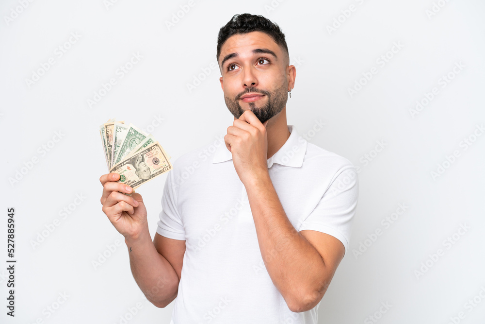Young Arab man taking a lot of money isolated on white background and looking up Young Arab man taking a lot of money isolated on white background and looking up