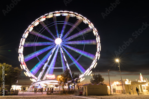 Italy, September 2022: view of the ferris wheel of Rimini with all the colored lights near the beach of the Riviera Romagnola