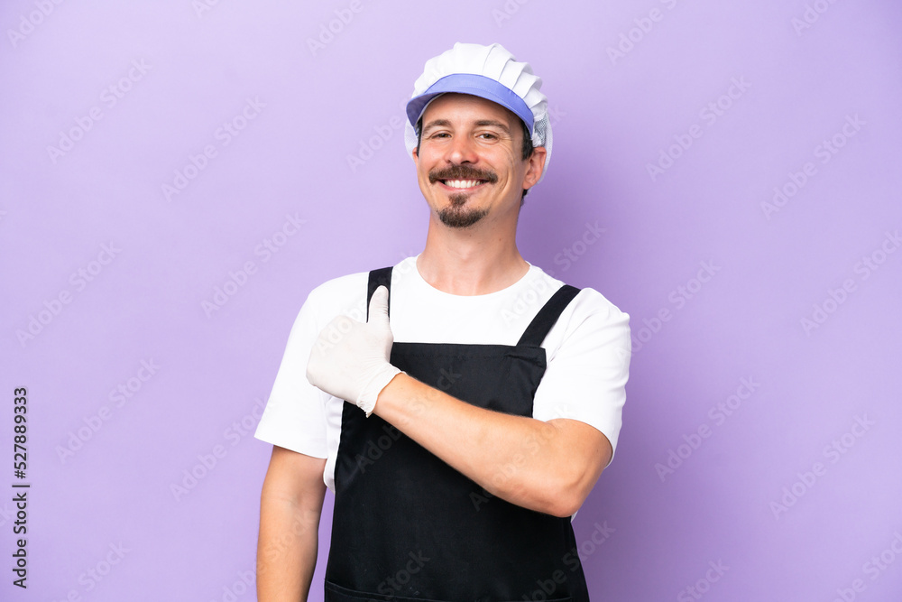 Fishmonger man wearing an apron isolated on purple background giving a thumbs up gesture Fishmonger man wearing an apron isolated on purple background giving a thumbs up gesture