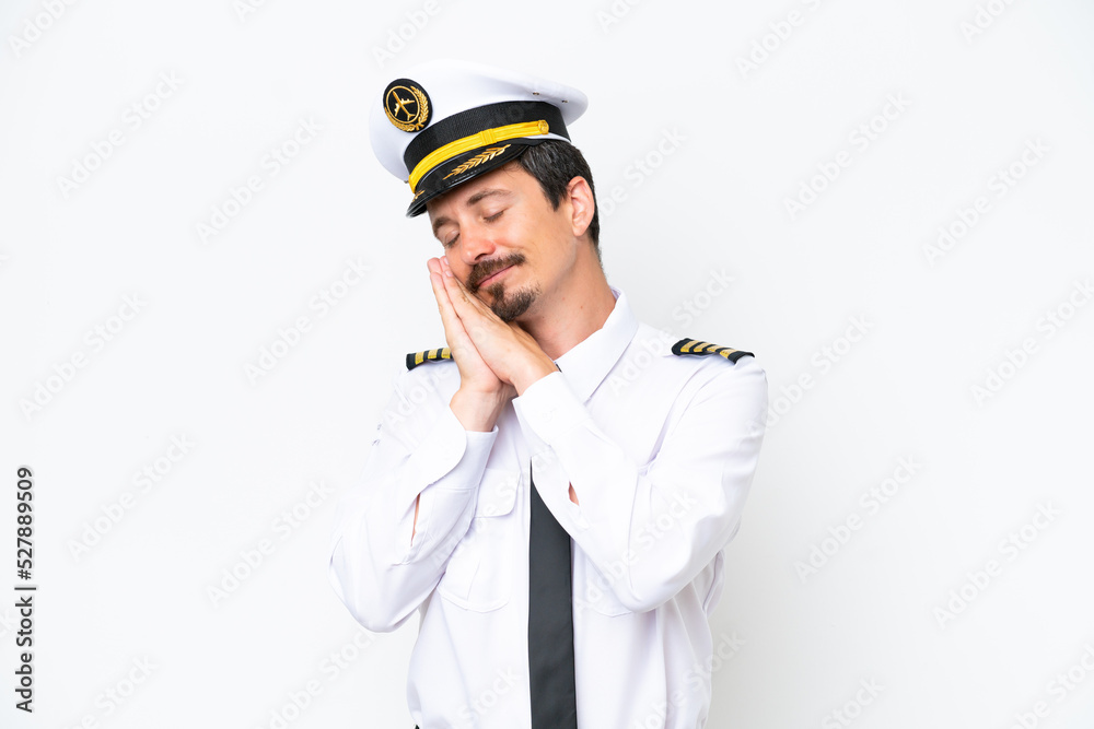 Airplane caucasian pilot isolated on white background making sleep gesture in dorable expression Airplane caucasian pilot isolated on white background making sleep gesture in dorable expression
