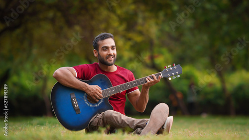 man guitar playing in park Indian boy