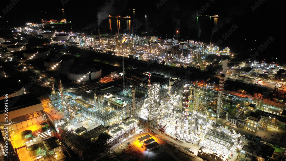 Aerial drone night shot of illuminated crude oil refinery in Mediterranean seaside destination