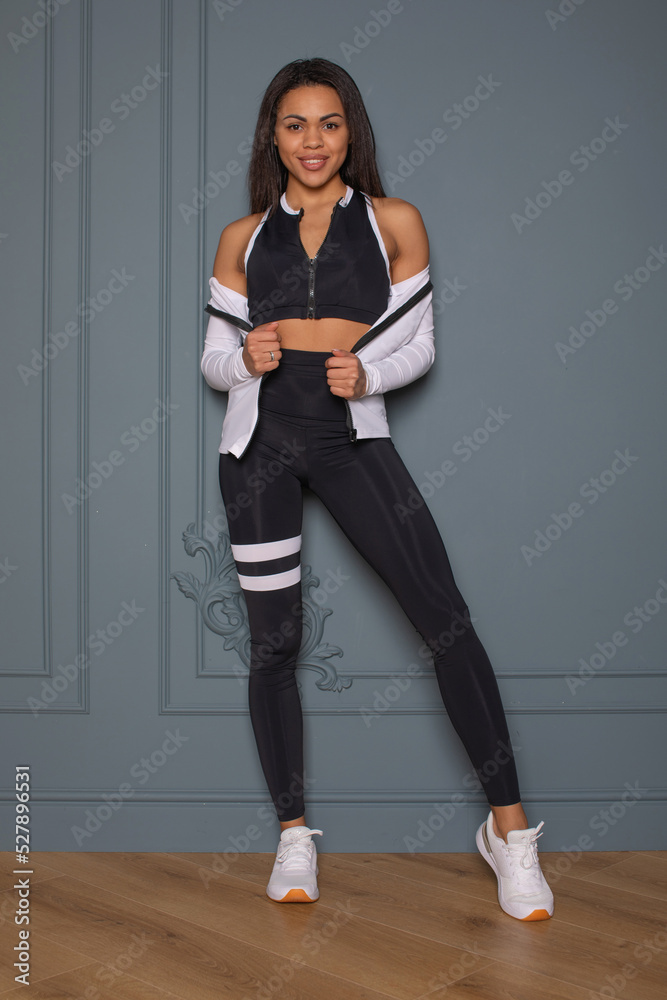 Portrait of fitness smiling black woman in sports clothing.Young female wearing sportswear. Beautiful model with perfect tanned body. Portrait of fitness smiling black woman in sports clothing.Young female wearing sportswear. Beautiful model with perfect tanned body.
