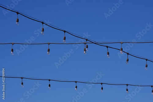 Electric string lights under blue skiy photo