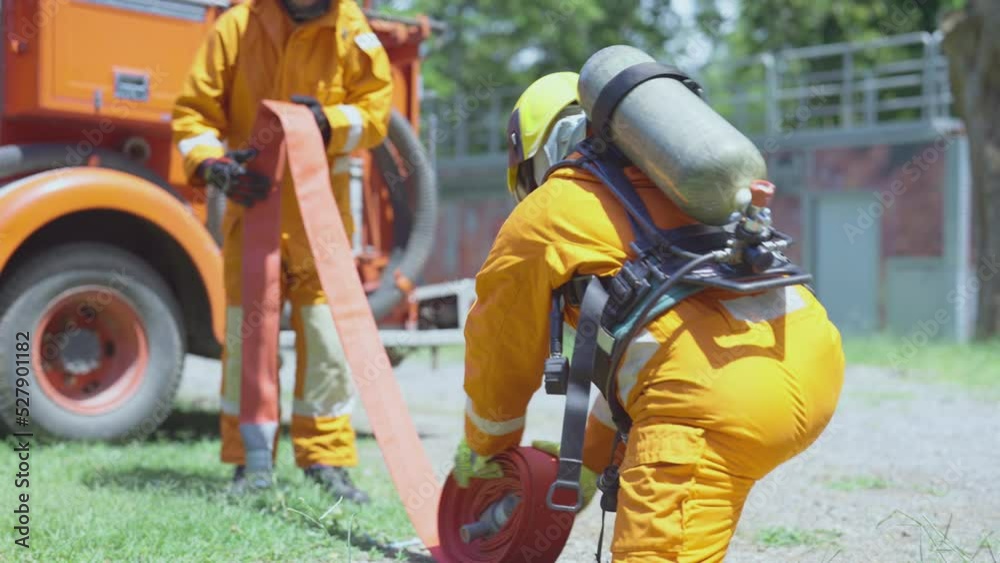 Fireman or firefighter team help to roll back fire pipe line after finish work of extinguish fire in workplace. Fireman or firefighter team help to roll back fire pipe line after finish work of extinguish fire in workplace.