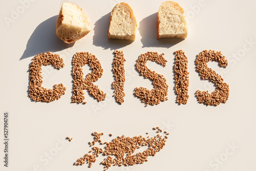 Word crisis from wheat grains and bread slices. The concept of problems with the supply of wheat and flour. Global food crisis. Top view, Flatley photo