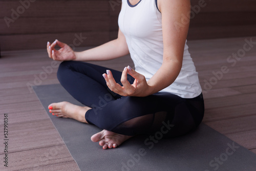 Fototapeta Naklejka Na Ścianę i Meble -  Beautiful strong muscular woman doing stretching on mat on terrace outdoors. Healthy young adult girl in  sportswear stretch alone. Fit thin gimnast doing yoga, training on mat	