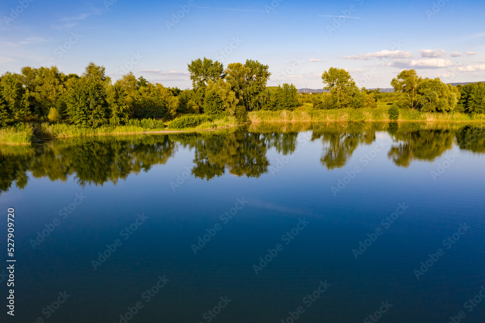 An aerial view with green trees on a blue lake An aerial view with green trees on a blue lake