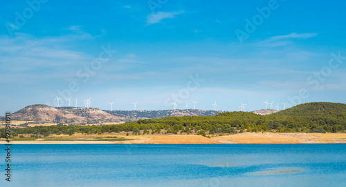 Windmills over a lake with blue water