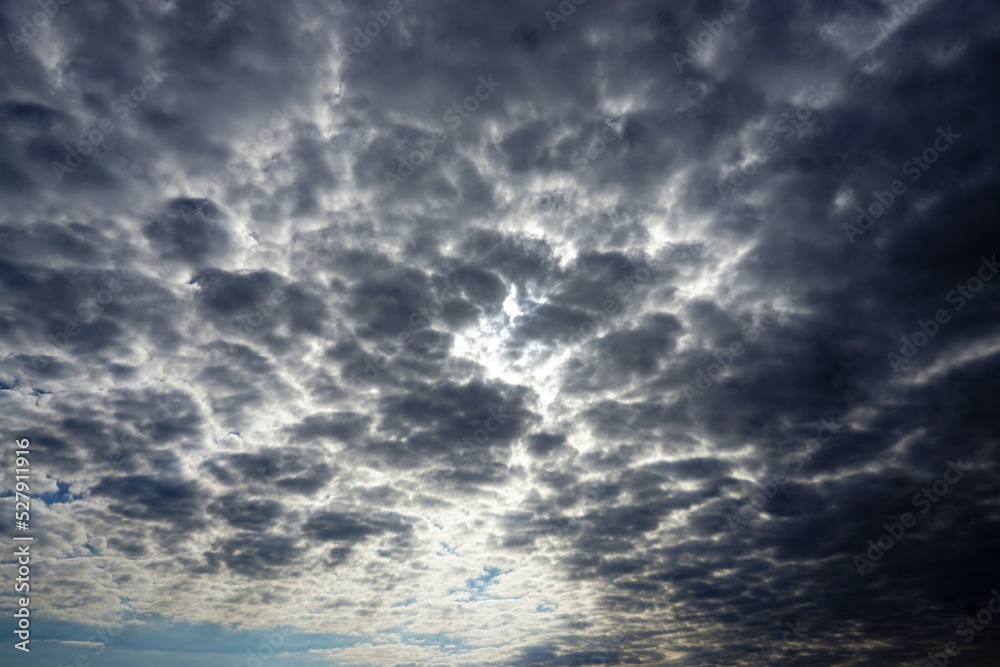 Bedeckte Himmellandschaft mit dramatischem grauen Wolkengebilde bei Sonne am Mittag im Sommer