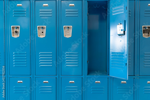 Fototapeta Single open empty blue metal locker along a nondescript hallway in a typical US High School