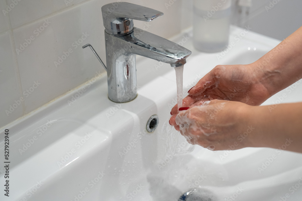close up woman washing hands with soap and water, white foam, in the bathroom, under tap in the sink, personal hygiene and care, coronavirus prevention close up woman washing hands with soap and water, white foam, in the bathroom, under tap in the sink, personal hygiene and care, coronavirus prevention