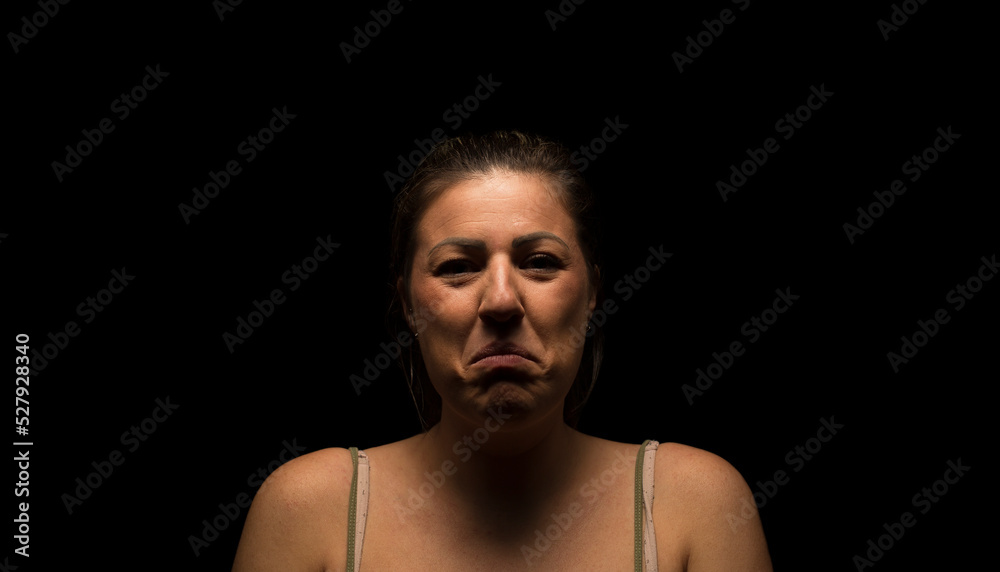 Caucasian adult woman looking into camera with a sad looking expression.