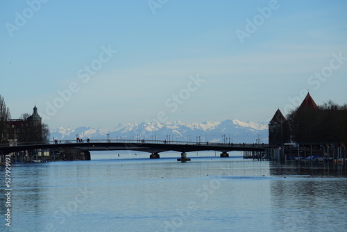 belebte Brücke in Konstanz mit Alpensicht an sonnigem Wintertag