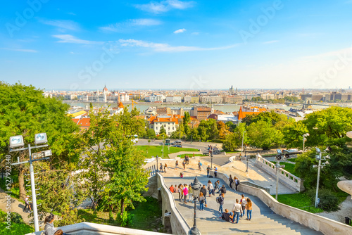 Tourists walk the long staircase from the Buda Castle Complex, with the Parliament Building and Danube River in view below.