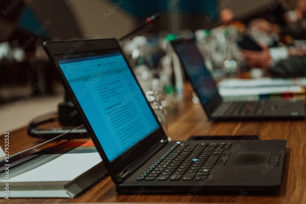 Photo of a laptop on a table in a modern seminar hall. Selective focus Photo of a laptop on a table in a modern seminar hall. Selective focus