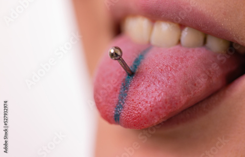 Obraz na plátně Close up portrait of young Caucasian woman sticking out pierced tongue