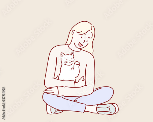 Young woman holds in her arms and hugs cat.