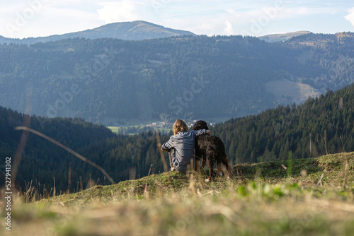 Hiking with dogs: A person enjoys the mountain view of the alps with a dog in late summer outdoors © Annabell Gsödl