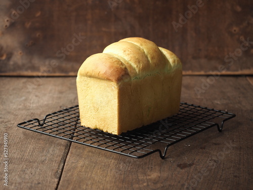 loaf of pandan bread on baking rack on wood photo