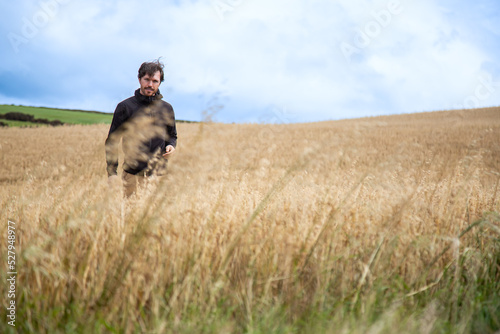 A young farmer on a wheat field in countryside of County Cork, Ireland © cabuscaa