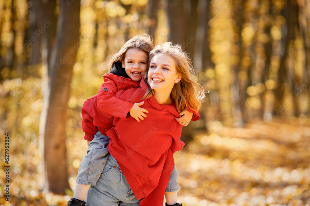 Mother and daughter walking and playing in autumn forest Mother and daughter walking and playing in autumn forest