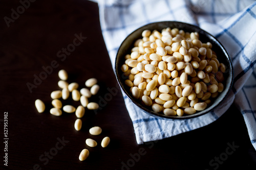 Soy beans in black ceramic bowl on platemat. Soaked japanese soy beans.