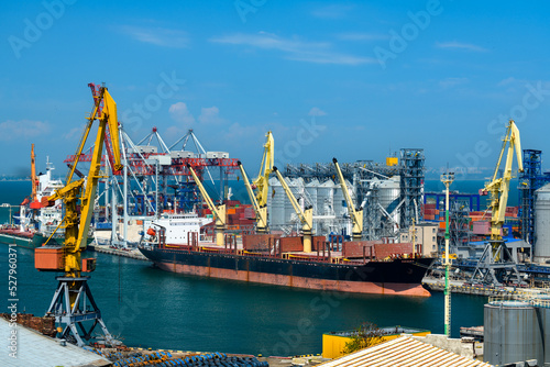 Fototapet industrial seaport infrastructure, sea, cranes and dry cargo ship, grain silo, b
