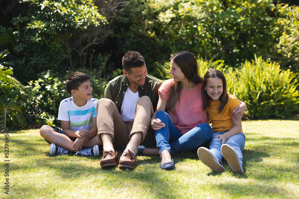 Caucasian family spending time in their garden together Caucasian family spending time in their garden together