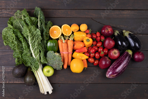 Directly above shot of various fresh organic fruits and vegetables on wooden table, copy space