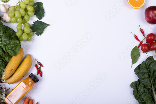 Overhead view of juice with various healthy food on white background, copy space