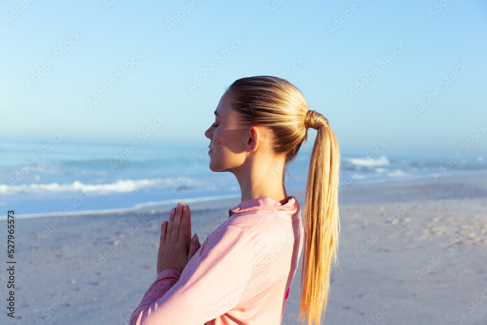 Caucasian woman practicing yoga seaside Caucasian woman practicing yoga seaside