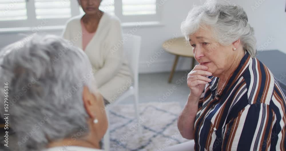 Diverse group of senior friends giving support to caucasian female friend on meeting Diverse group of senior friends giving support to caucasian female friend on meeting