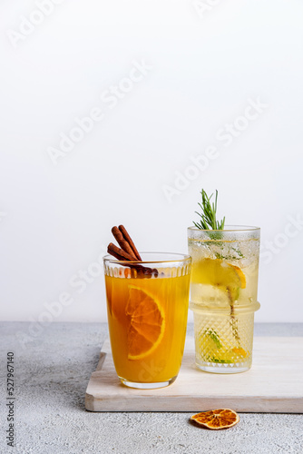 Two vibrant and sparkling non-alcoholic punch is perfect for summer gatherings . Colorful Christmas cocktails in glasses on white table. Fresh holiday drinks.