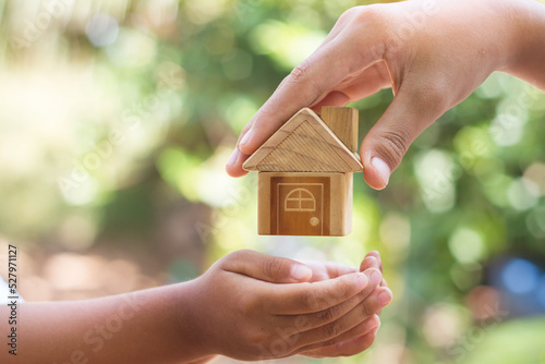 hand is giving a model of a house to child's hand, Concept for Investing in long-term real estate for the future. Inheritance concept. Inherited property idea.