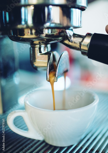 Close up of coffee pouring from espresso in cup