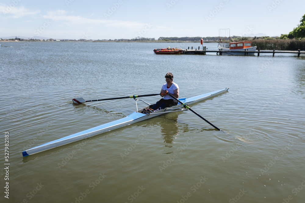 Senior caucasian rowing woman rowing the boat on the lake Senior caucasian rowing woman rowing the boat on the lake