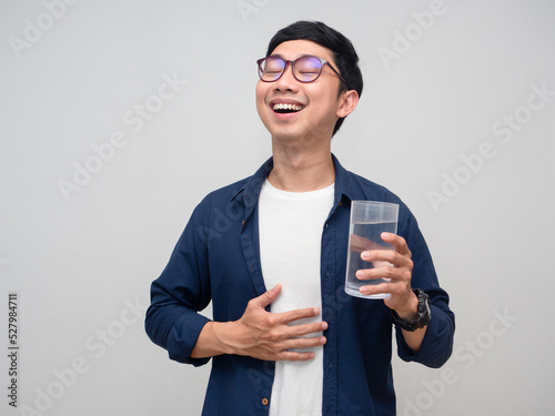 Healthy asian man feels fresh with drinking water in hand isolated