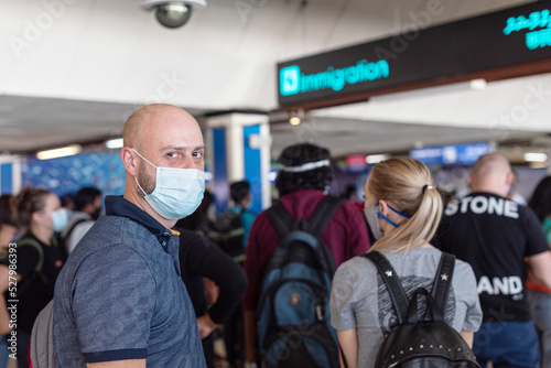 Male, Maldives - November 2020: man in face protective mask queue for customs on arrival in the Maldives at Male airport in a new reality due to the coronavirus pandemic
