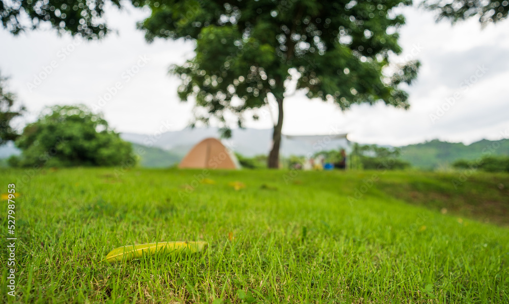 Blur of Tourist tent on green grass under trees with mountain view, holiday camping. Blur of Tourist tent on green grass under trees with mountain view, holiday camping.