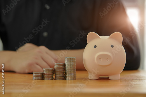 ฺBusinessman saving money by putting a coin into piggy bank concept saving money for finance accounting 