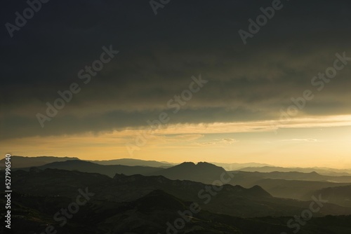 sunset over the mountains, in low light with gold sky © Leonardo