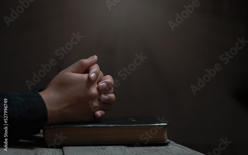 Foto praying hands, young woman prayer with hands together over a Holy Bible on wooden table