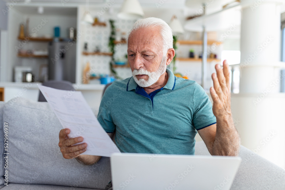 man worried about his monthly payments. Serious senior man holding letter feels interested read business news, got invitation, learns bank statement information. Postal correspondence concept man worried about his monthly payments. Serious senior man holding letter feels interested read business news, got invitation, learns bank statement information. Postal correspondence concept
