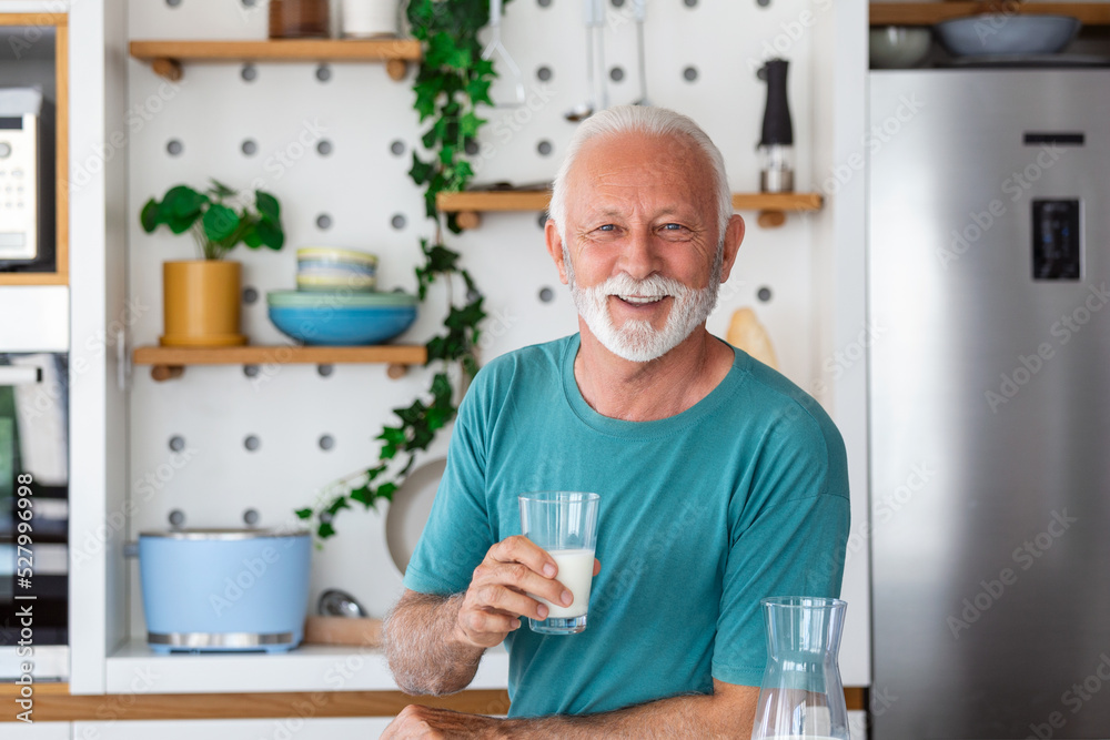 Senior man drinking a glass of milk with a happy face standing and smiling. Handsome senior man drinking a glass of fresh milk in the kitchen Senior man drinking a glass of milk with a happy face standing and smiling. Handsome senior man drinking a glass of fresh milk in the kitchen