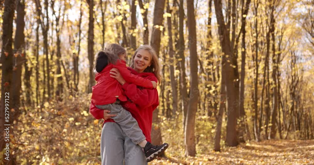 Young blond mother with daughter walk in the autumn forest Young blond mother with daughter walk in the autumn forest